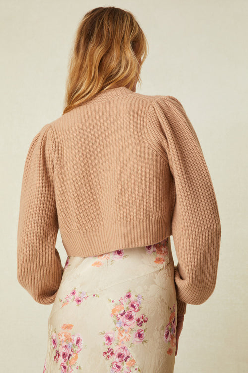  cashmere-wool blend cropped sweater, has a v-neck that descends to three buttons at center front. Pleated blouson sleeves extend to ribbed cuffs at opening.