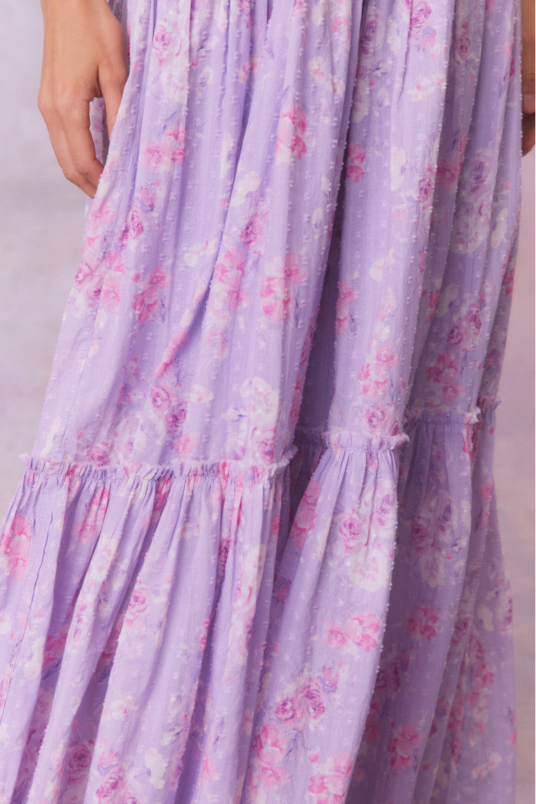 Purple floral print maxi dress with flutter sleeves and a tiered maxi skirt.