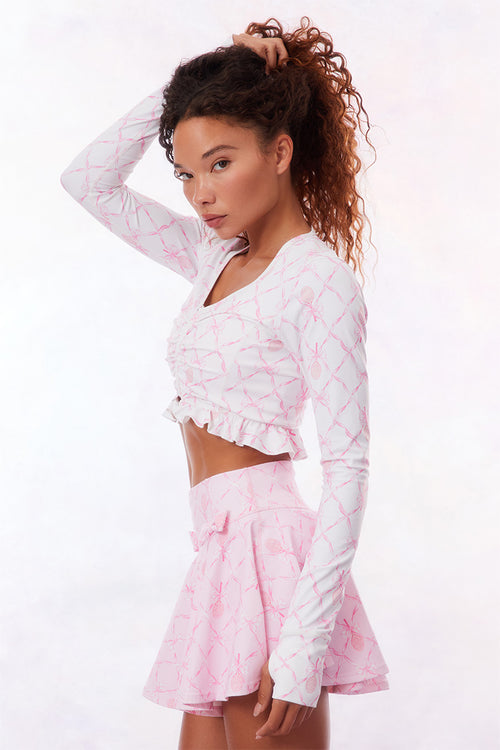 Pink active skort with a bow and tennis raquet pattern. Two pink bows placed on each frontside of hip.