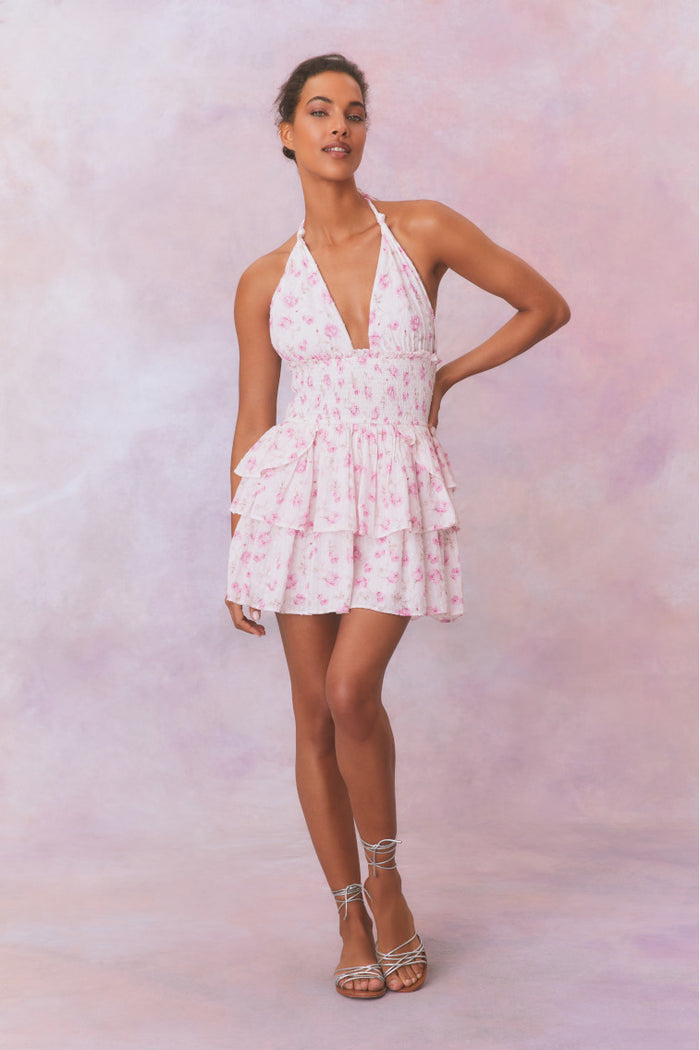 White floral low-cut halter dress with a smocked waistband and two ruffled tiers.