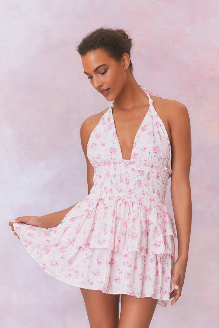 White floral low-cut halter dress with a smocked waistband and two ruffled tiers.