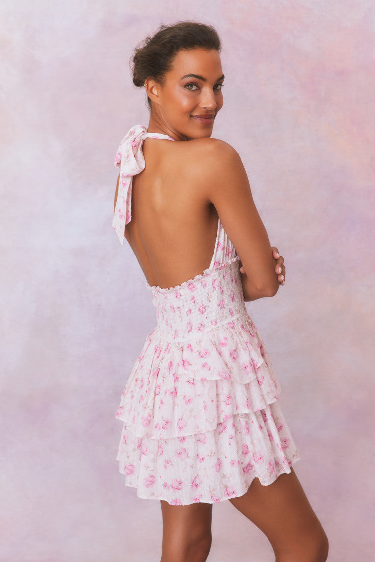 White floral low-cut halter dress with a smocked waistband and two ruffled tiers.