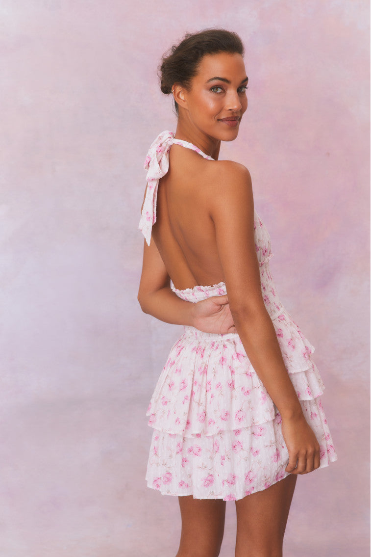 White floral low-cut halter dress with a smocked waistband and two ruffled tiers.