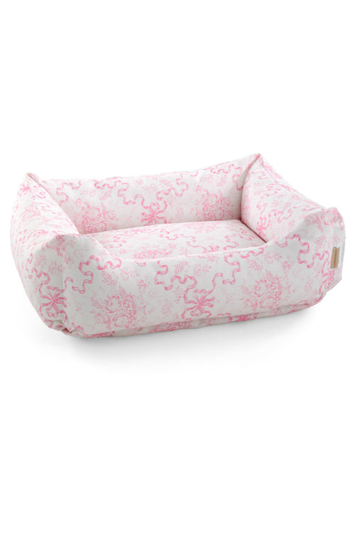 Dog bed with a bow and floral print.