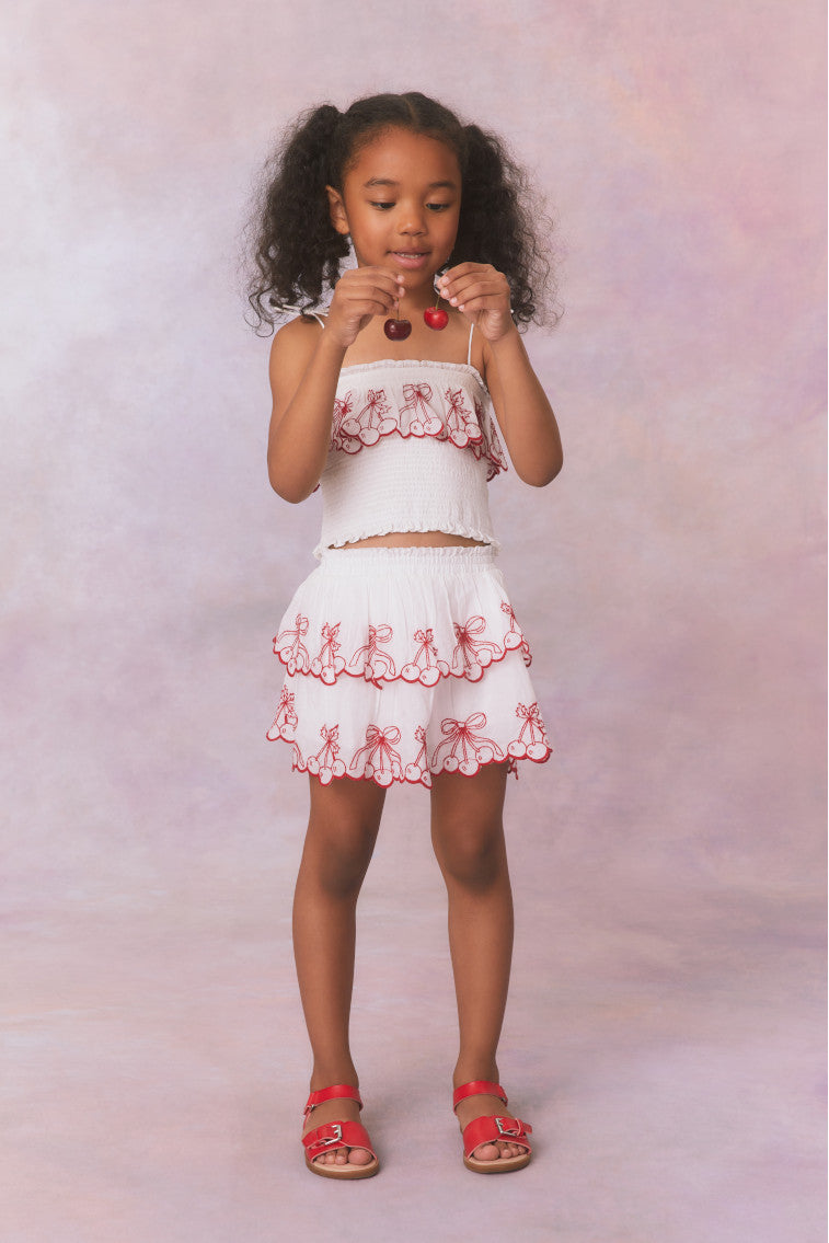 White double lined ruffle mini skirt with elastic waistband, made with airy cotton fabric and cherry embroideries as a scallop detail.