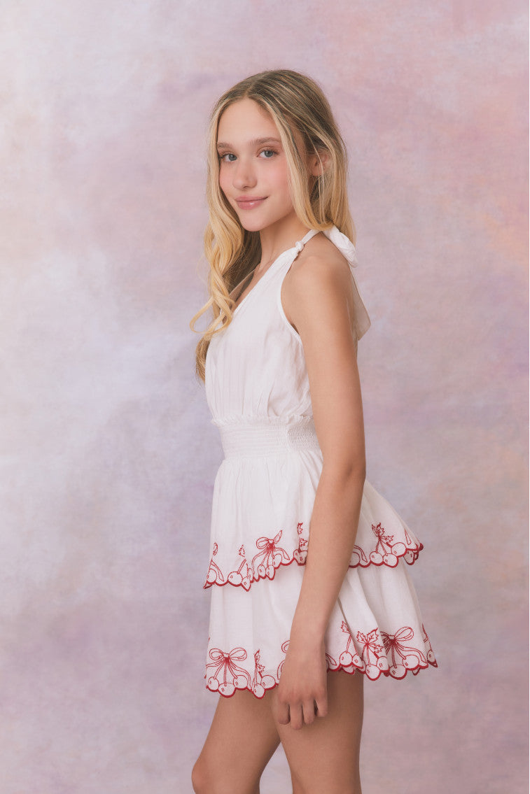 White halter v-neck dress with elastic waistband and cherry embroidery on the two tiered skirt for girls.