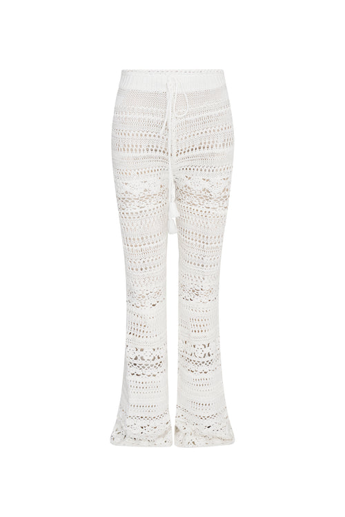 White cotton pointelle crochet floral flare pants with a self tie detail at center front on the double ribbed waistband.