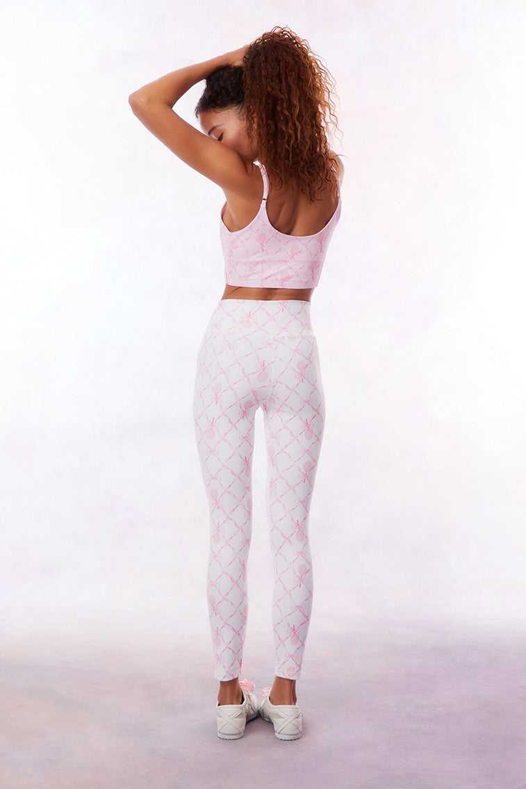 White active legging with a pink colored bow and tennis raquet pattern. 