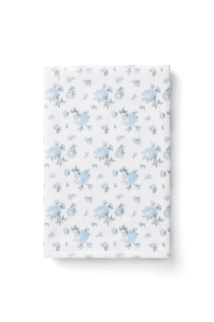 vintage-inspired delicate repeating mini floral print bath towel in a soft blue against a white back