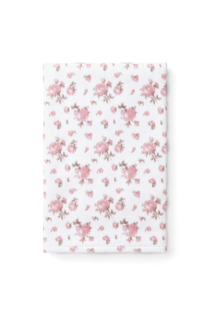 vintage-inspired delicate repeating mini floral print bath towel in a soft pink against a white back