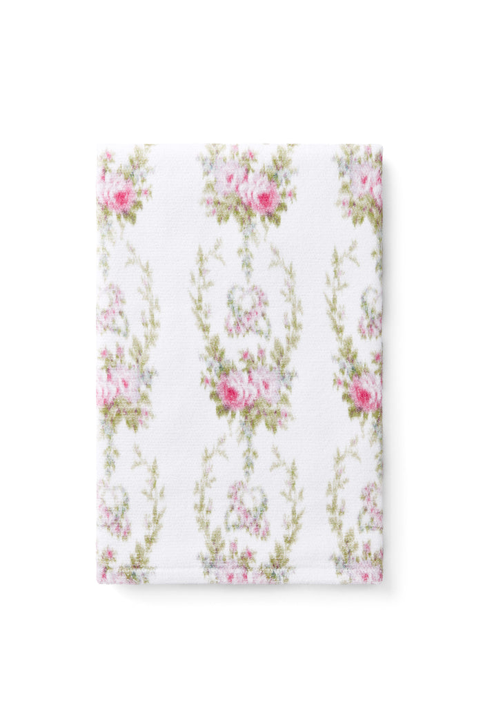 vintage-inspired repeating floral print bath towel in a soft pink against a white back