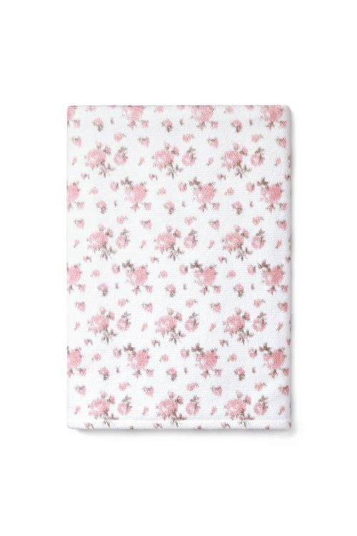 vintage-inspired repeating floral print bath towel in a soft pink against a white back