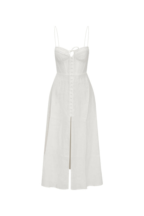 White maxi dress featuring thin spaghetti straps, bustier-inspired cups at the bust with shirring details, a playful keyhole cutout, a center front placket that stops at the hip above a center front slit.