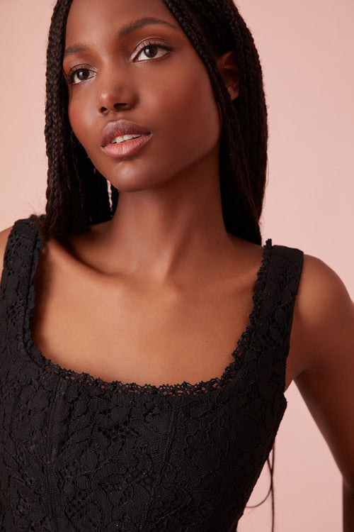 Black bustier top with an open square neck, a V-shaped base and an array of different handmade flowers.