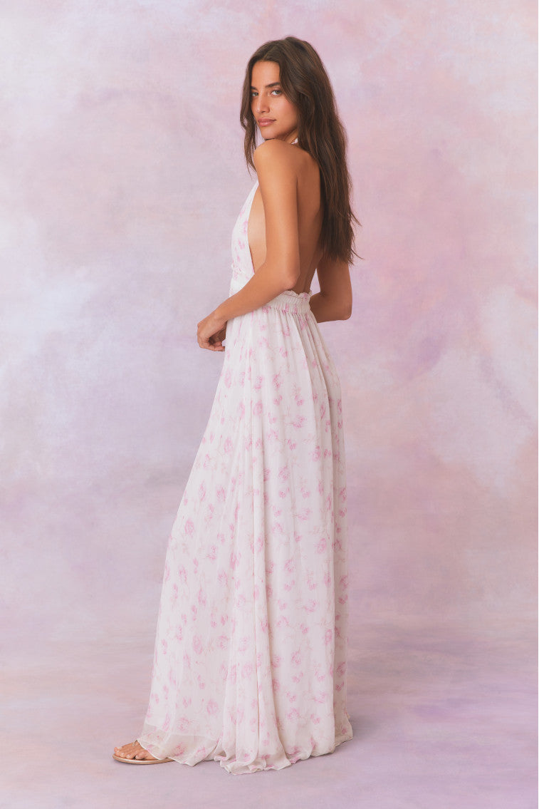 White backless floral halter maxi dress that ties in the back, flowing into an airy skirt.