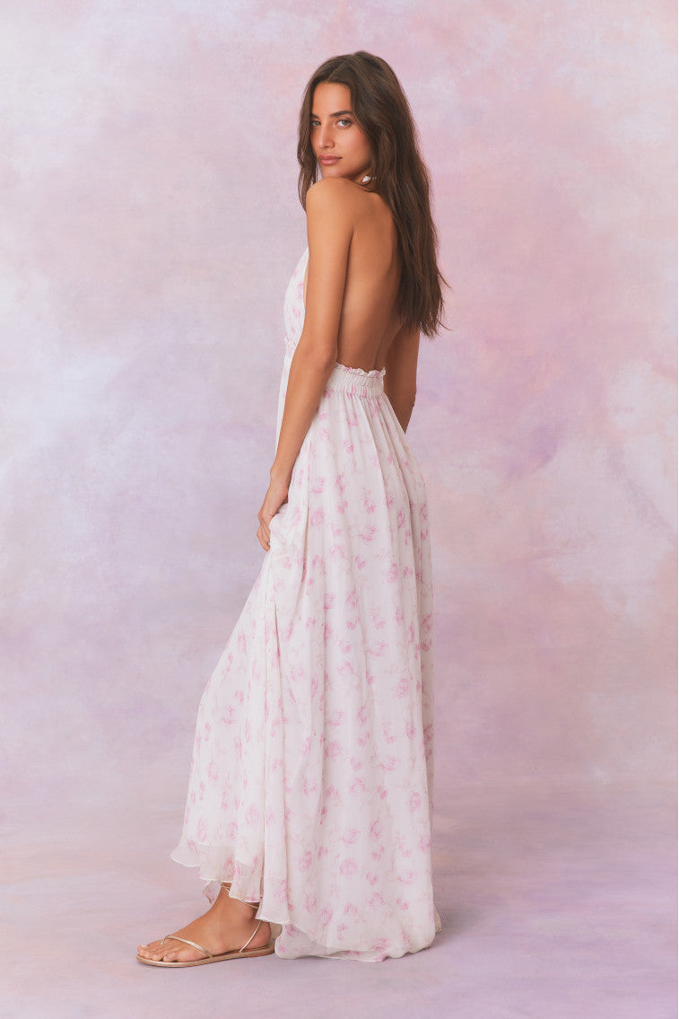 White backless floral halter maxi dress that ties in the back, flowing into an airy skirt.