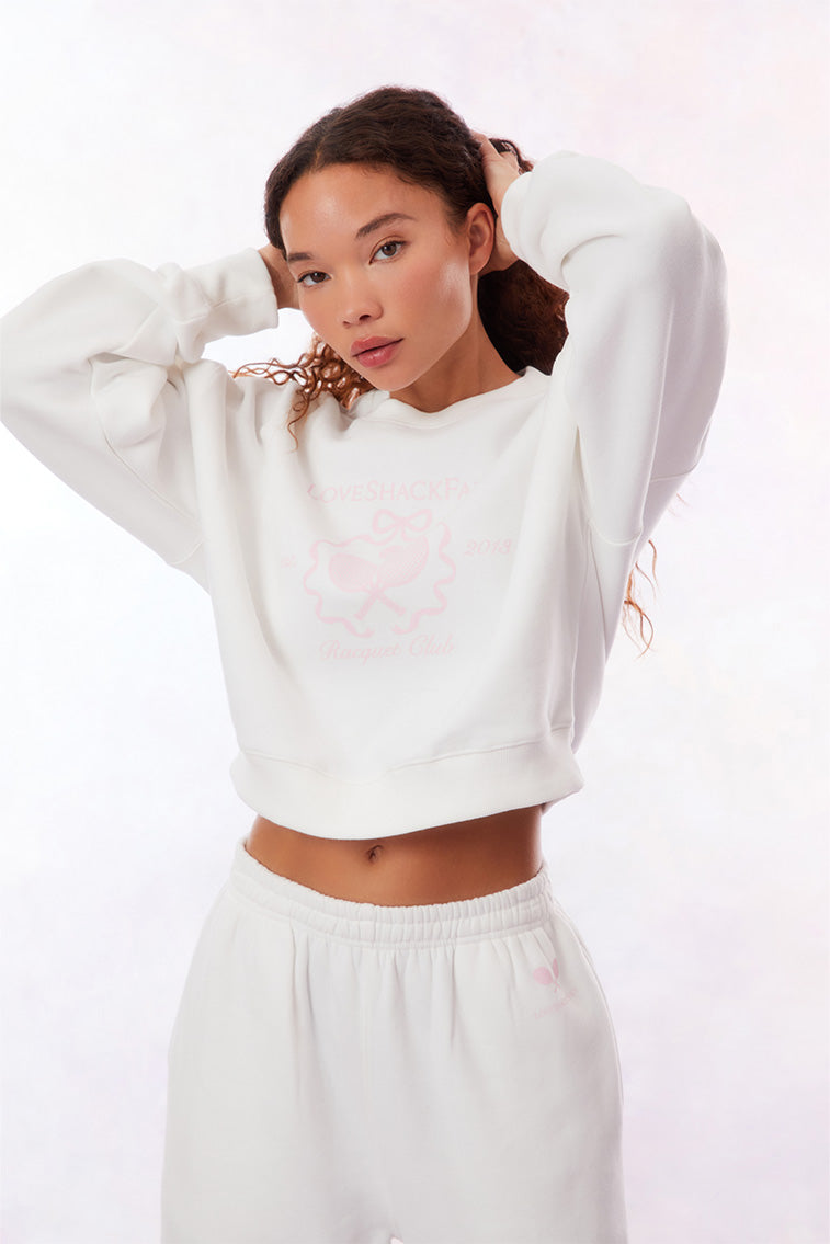 White joggers with an elastic waist and elastic leg openings. The pink LoveShackFancy Racquet logo is on the hip.