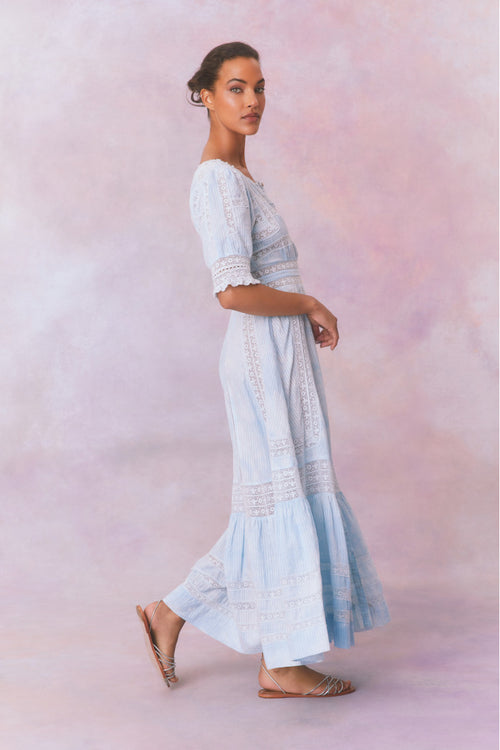 Blue cotton maxi dress with floral and lace detail, with buttons down center front, quarter length sleeves, a fixed waist, and a full sweeping skirt.