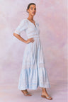 Blue cotton maxi dress with floral and lace detail, with buttons down center front, quarter length sleeves, a fixed waist, and a full sweeping skirt.