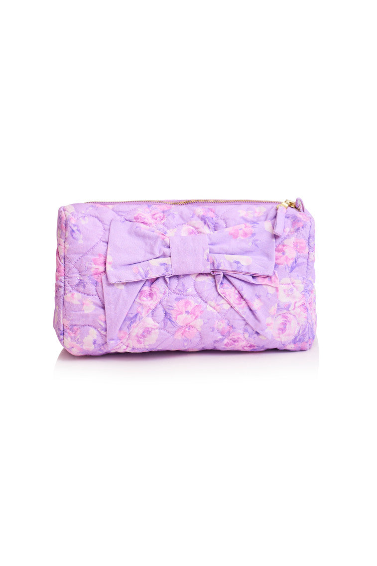 Purple floral quilted bag that can be used for travel or makeup, has a bow on front of the bag
