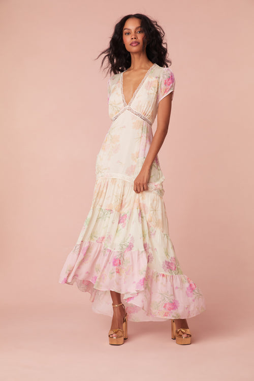 Maxi dress with a floral print mix in pink, cream, and light green. This dress begins with a v-neckline and a lace-trimmed waist seam, falling to a flowy skirt.