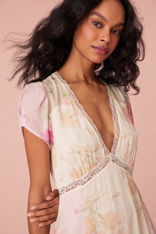 Maxi dress with a floral print mix in pink, cream, and light green. This dress begins with a v-neckline and a lace-trimmed waist seam, falling to a flowy skirt.