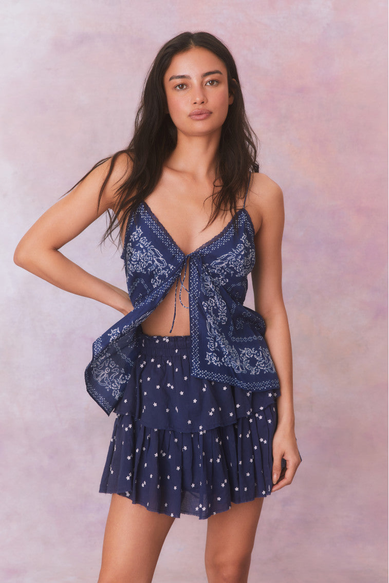 Blue lightweight silk habotai spaghetti strapped cami with a bandana print, a scoop neckline, and tie detail at the front.