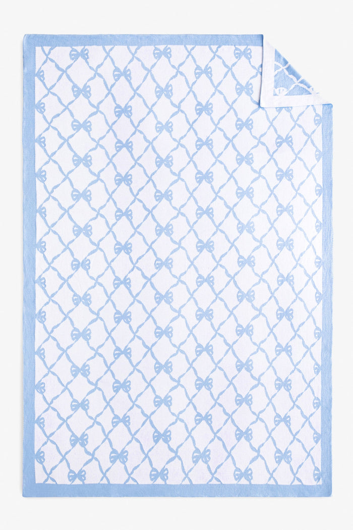 Reversible throw blanket with bow print.